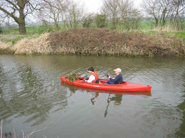 A voluntary weed picking crew with a bundle of weed on the foredeck in Ricketts Lock Cut, April 2005